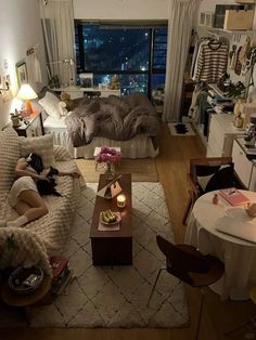 a woman laying on top of a couch in a living room next to a window