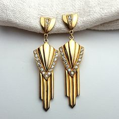 Over the top! Hollywood regency art deco style drop dangle earring clip ons from the 1980s. Gold plated metal set with rhinestones. Total length 8 cms. Drop length 6x2,3 cms. Upper, metal part is 1,5x1,5 cms. Suitable for anyone who wants to set the hot Hollywood luxury glamour style spot on... Fine vintage gift for her. Pre-owned. Clip ons works well. Minor wear on gold pleating. One rhinestone slightly darkened. WORLDWIDE SHIPPING INCLUDED IN PRICE. I SEND FROM SWEDEN, SCANDINAVIA AND DELIVERY Luxury Mid-century Clip-on Earrings, 80s Art Deco, 80s Art, Deco Jewelry, Drop Dangle Earrings, Art Deco Jewelry, Hollywood Regency, Art Deco Style, Vintage Gifts