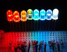 an array of different colored lights sitting on top of a board