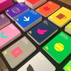 many different colored notebooks are arranged on a table with the same color as each other