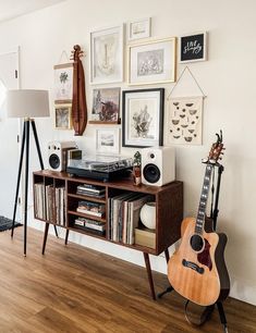 a room with a guitar, record player and other items on the table in front of it