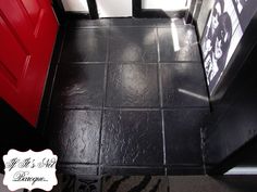 a black tile floor with red door and white walls