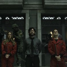 a group of people standing next to each other in front of a building with soldiers