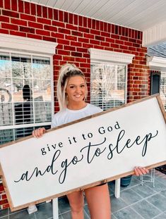 a woman holding up a sign that says give it to god and go to sleep