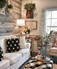 a living room filled with furniture and flowers in vases on top of the tables