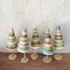 four miniature christmas trees on wooden bases