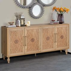 a wooden sideboard with decorative mirrors above it