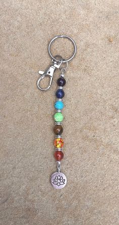 a keychain with seven chakras on it sitting on top of a stone floor