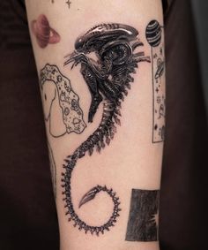 a black and white photo of a tattoo with an alien on it's arm