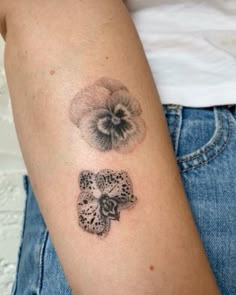 a woman's arm with an owl and flower tattoo on the left side of her arm