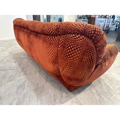 an orange couch sitting on top of a marble floor