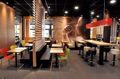 an empty restaurant with tables and chairs in the middle of it, next to a large poster on the wall