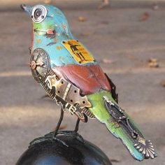 a colorful bird sitting on top of a black ball