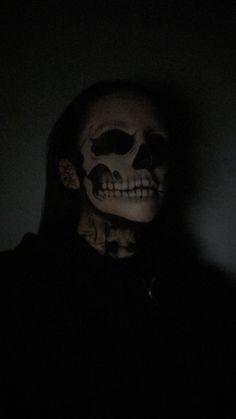 a person in a dark room wearing a skeleton mask