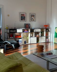 a living room filled with lots of furniture and pictures on the wall next to it