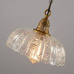 an old fashioned glass light hanging from a chain