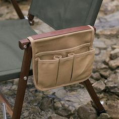 two folding chairs sitting next to each other on top of a rock covered ground with rocks in the background