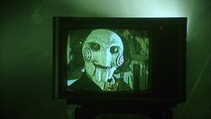 an old television with a creepy face on it's screen in a dark room