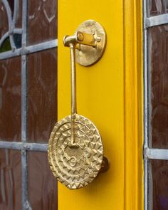 a gold door handle on a yellow door