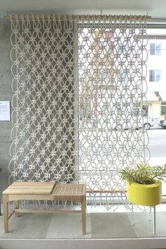 a living room with a couch, table and window covered in sheer curtains on the windowsill