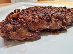 two pieces of meat sitting on top of a white plate