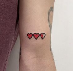 a woman's arm with three hearts tattooed on the left side of her arm