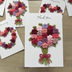 some cards with flowers on them sitting on a table