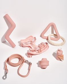 various pink objects are arranged on a white surface, including an object that appears to be part of a collection