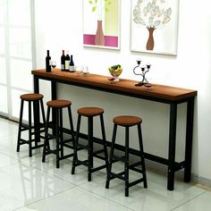 three bar stools sit at the end of a table