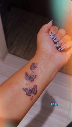 a woman's arm with three butterflies on it and the word love written in cursive writing