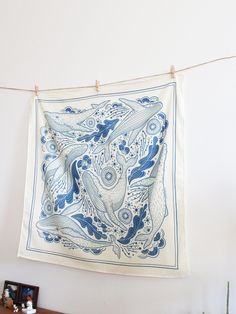 a blue and white artwork hanging on a wall