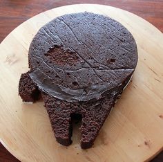 a piece of chocolate cake sitting on top of a wooden plate next to a knife