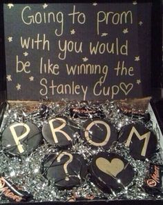 a box filled with lots of badges and some writing on the front, along with a sign that says going to prom with you would be like winning the stanley cup?