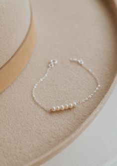 The bracelet version of our Pearl Linked Necklace. Let each of these pearls symbolize something special in your life. Use it as a daily reminder to count your blessing. 2-7 pearls are attached to our dainty cable chain. Bracelet is adjustable from 6.5 - 7". Available in 14kt Gold Fill + Sterling Silver. Layered with our Birdie Initial Bracelet. Handmade in Eau Claire, WI. Our jewelry is handmade so each piece will be unique and may vary slightly from what is pictured. Chain Bracelet With Beads, Handmade Chain Bracelet, Handmade Pearl Bracelets, Pearl Bracelets Ideas, Silver Beaded Jewelry, Dainty Adjustable Pearl Bracelet Gift, Dainty Pearl Chain Bracelet, Delicate Chain Pearl Bracelet Gift, Dainty Adjustable Pearl Bracelet