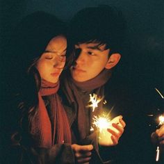 two people holding sparklers in their hands