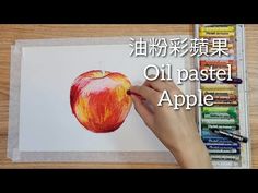 someone is drawing an apple with colored pencils