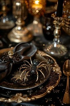 a table topped with black and gold plates covered in spider decorations