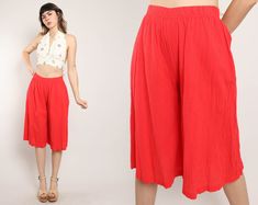 "FEATURES - 1980s pants - Red color - Gaucho style - Gauzy fabric - Elastic waist  - Wide leg - Cropped cut CONDITION Excellent vintage condition: a few pinhead markings on the pant legs (see photos). MEASUREMENTS & FIT suggested letter size: S (tag is marked a vintage women's US small) rise: 12.5\" waist: 24\"-30\" hip: 40\" length: 28\" inseam: 16\" color: red material: 100% cotton, elastic label: Amy Jess pinned on model? no Note on fit: Adrianne is 5'10 33-25-36 with a modern dress size 2-4, Casual Red Summer Capris, Vintage Wide Leg Summer Bottoms, Vintage Red Summer Bottoms, Red Vintage Summer Bottoms, Red Short Pants For Summer, Red Spring Shorts, Red Spring Short Pants, Modern Dress, Long Shorts