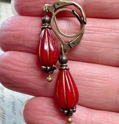 Red/Wine melon Czech glass beads are paired with antiqued brass to give them a vintage feel. The earrings are about 1 1/2 inches long and come in a gift box or gift bag. Red Brass Earrings With Ear Wire, Red Brass Drop Earrings, Vintage Red Brass Earrings, Red Brass Dangle Jewelry, Vintage Red Teardrop Jewelry, Antique Red Dangle Jewelry, Nickel-free Red Brass Earrings, Red Beaded Brass Jewelry, Unique Red Brass Earrings