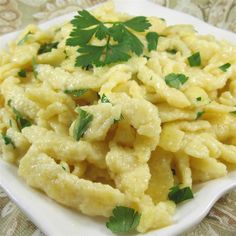 a white plate topped with macaroni and cheese covered in parsley