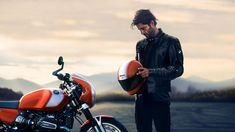 a man standing next to a red motorcycle