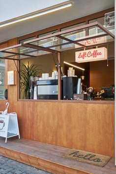 the outside of a coffee shop with an awning over it's entrance and counter