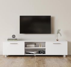 a flat screen tv mounted to the side of a white entertainment center in a living room