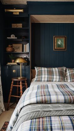 a bedroom with blue walls and plaid bedspread