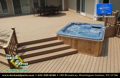 a hot tub sitting on top of a wooden deck next to a patio with stairs