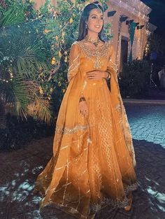 a woman in an orange gown standing outside