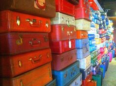 many different colored suitcases are stacked on each other