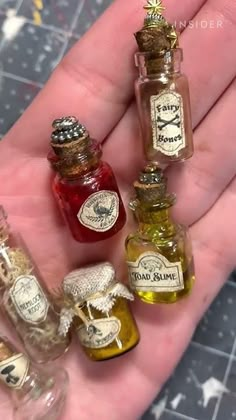 miniature bottles filled with different types of liquid in the palm of someone's hand