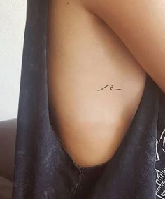 a woman with a small wave tattoo on her back