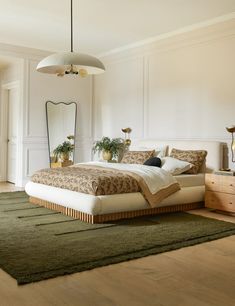 a bedroom with a large bed, dresser and mirror in it's center area